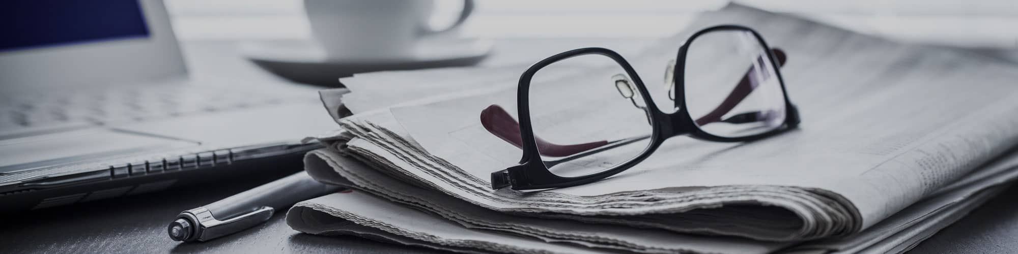 Newspaper and glasses on desk