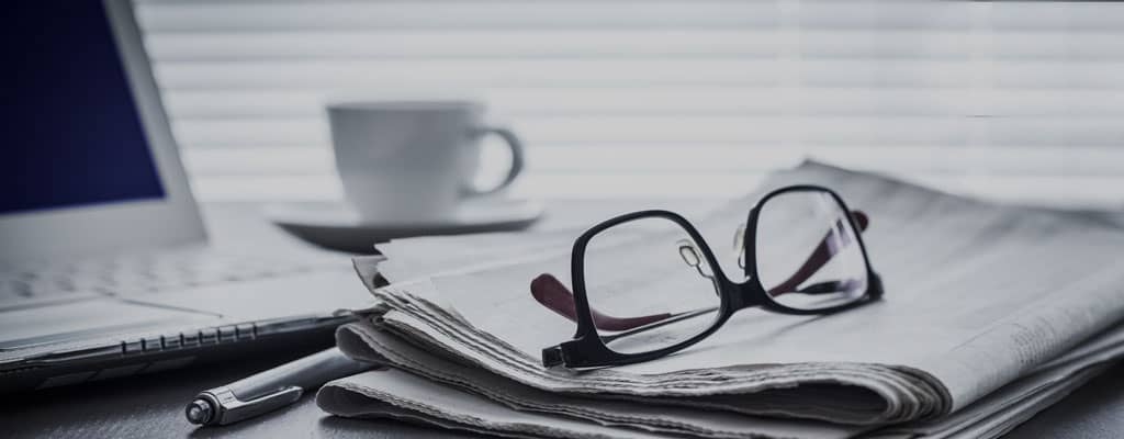 Newspaper and glasses on desk
